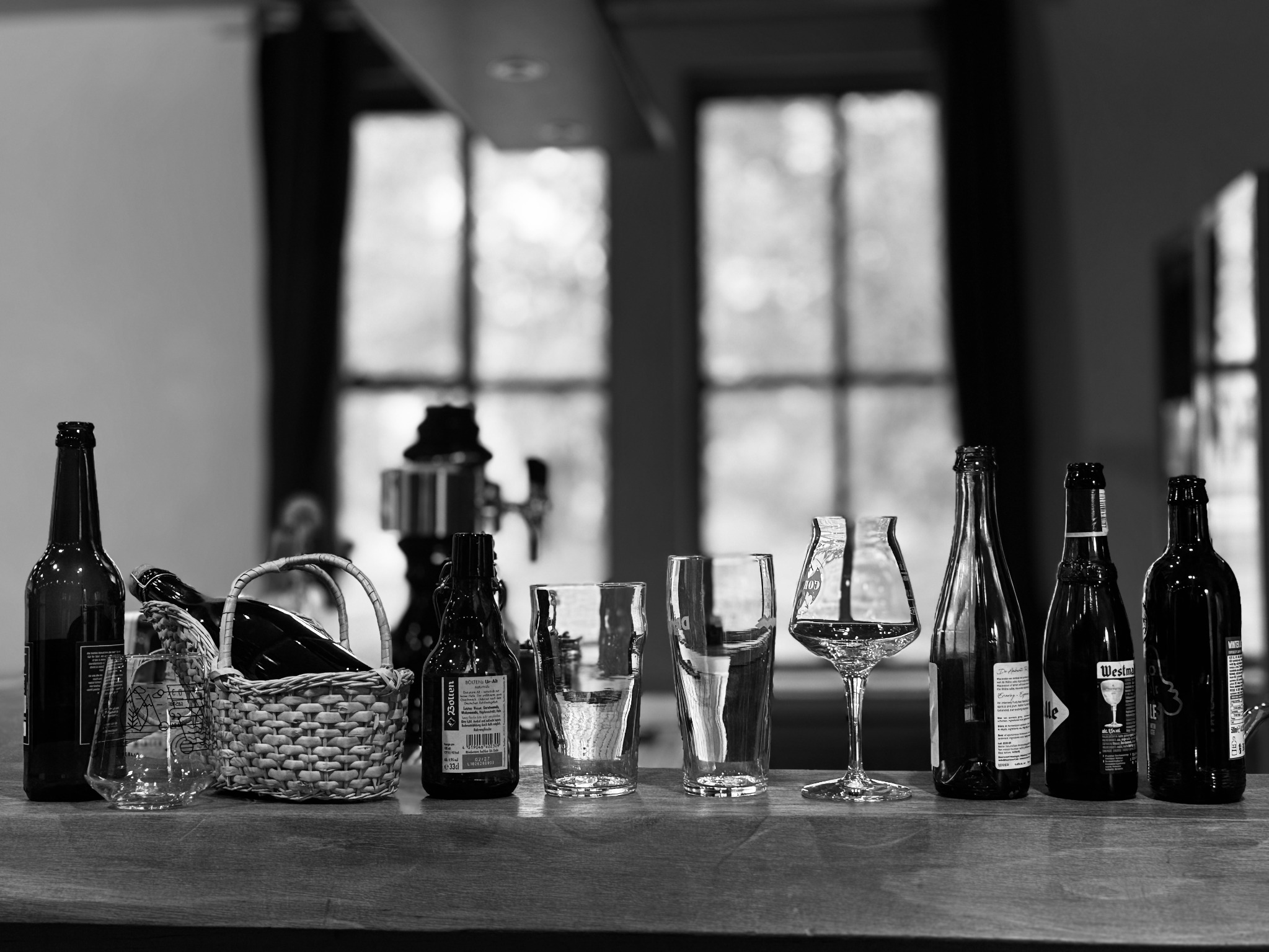 Bierflaschen und Verkostungsgläser auf einer Theke